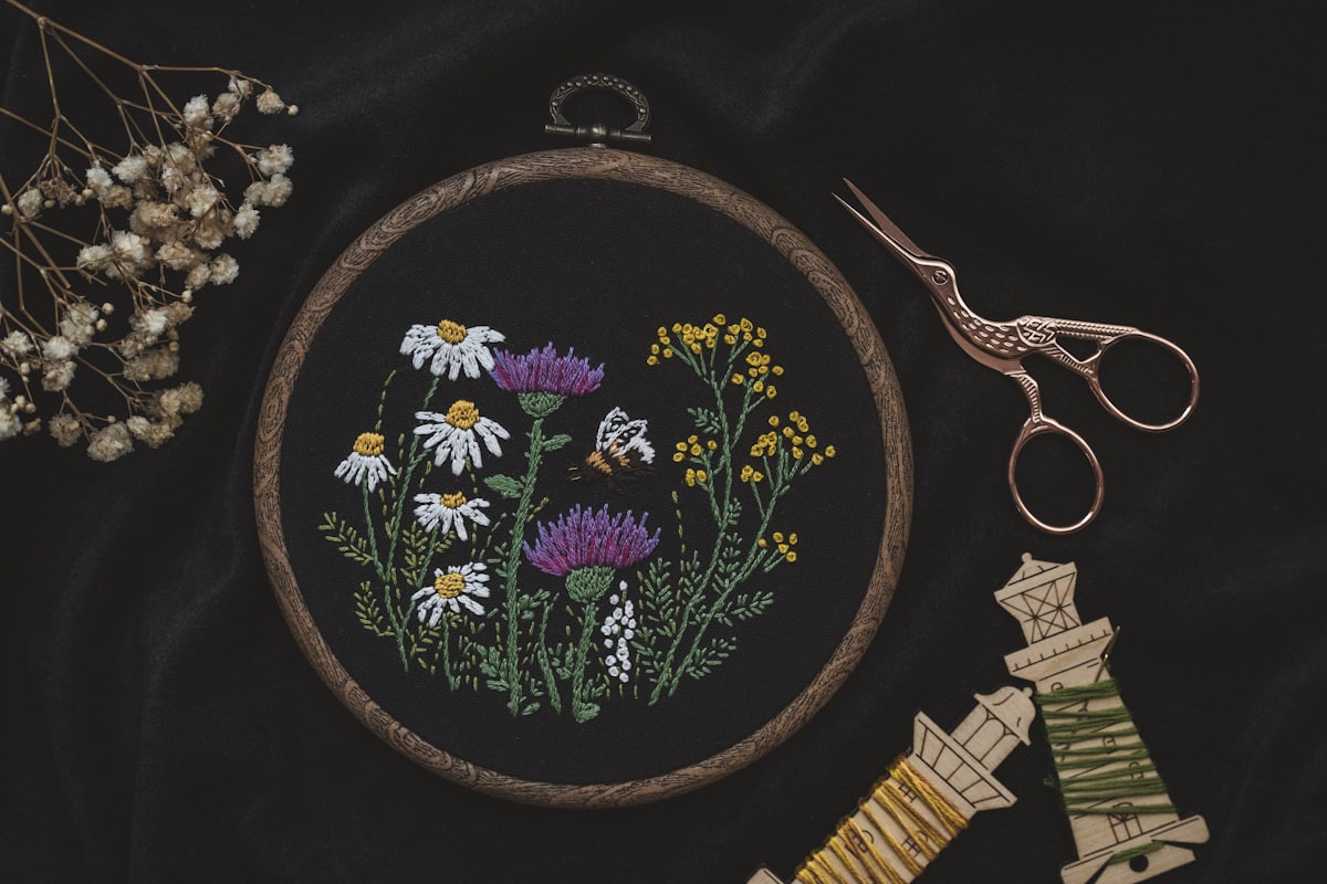 Bordado floral sobre tela clara junto a unas tijeras